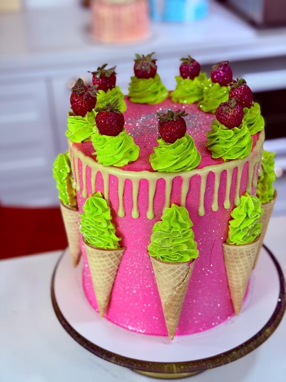 Bolo rosa decorado com casquinhas, rosetas verdes de chantilly e morangos