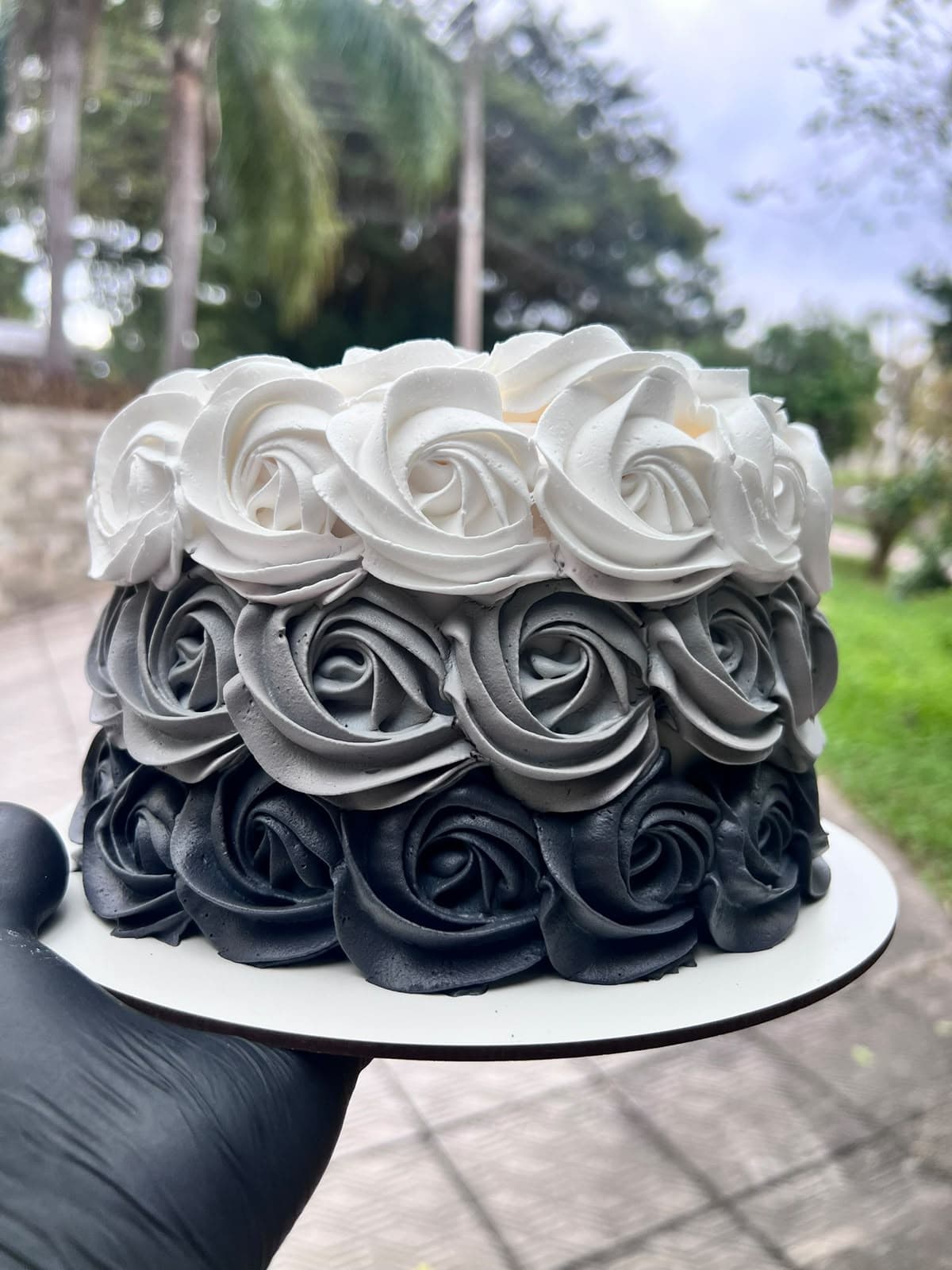 Bolo com rosetas de chantilly em degradê de branco, cinza e preto