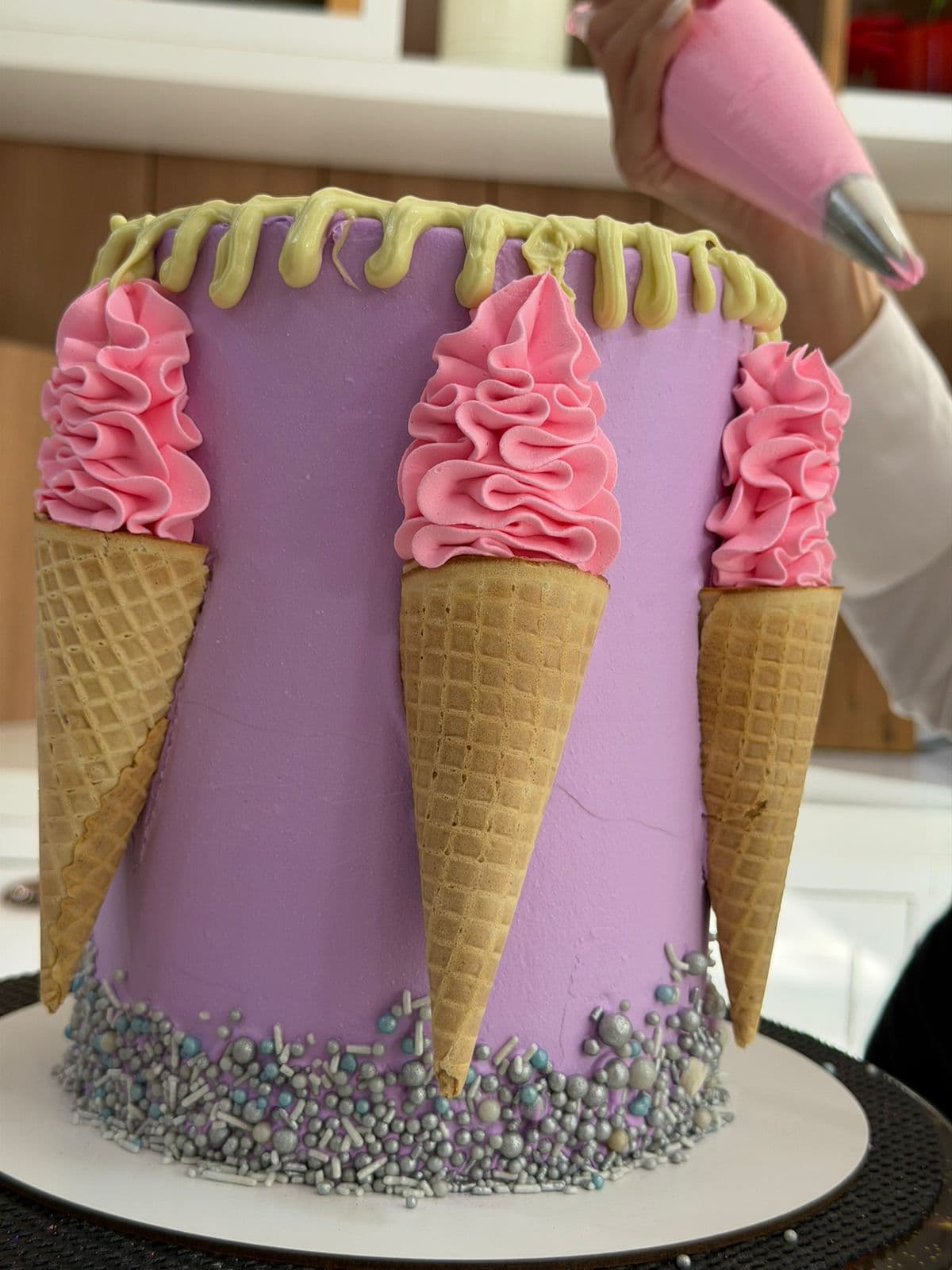 Bolo lilás decorado com casquinhas e rosetas cor-de-rosa
