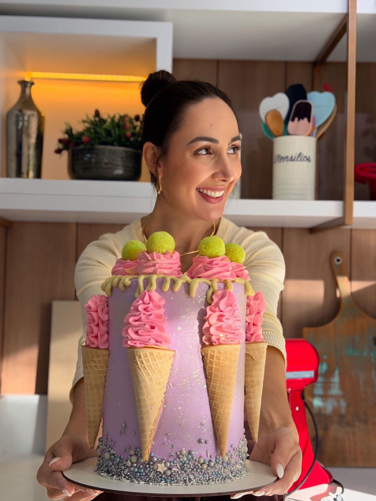 Confeiteira segurando um bolo com casquinhas e rosetas